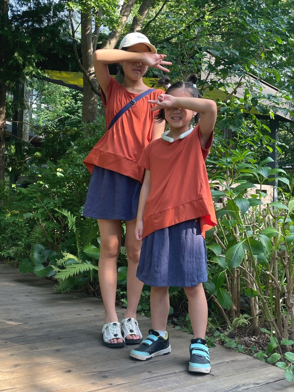 オレンジ系のTシャツ/カットソー、オレンジ系のTシャツ/カットソー、ブルー系のスカートを着用したレディースの夏コーディネートの2枚目の写真