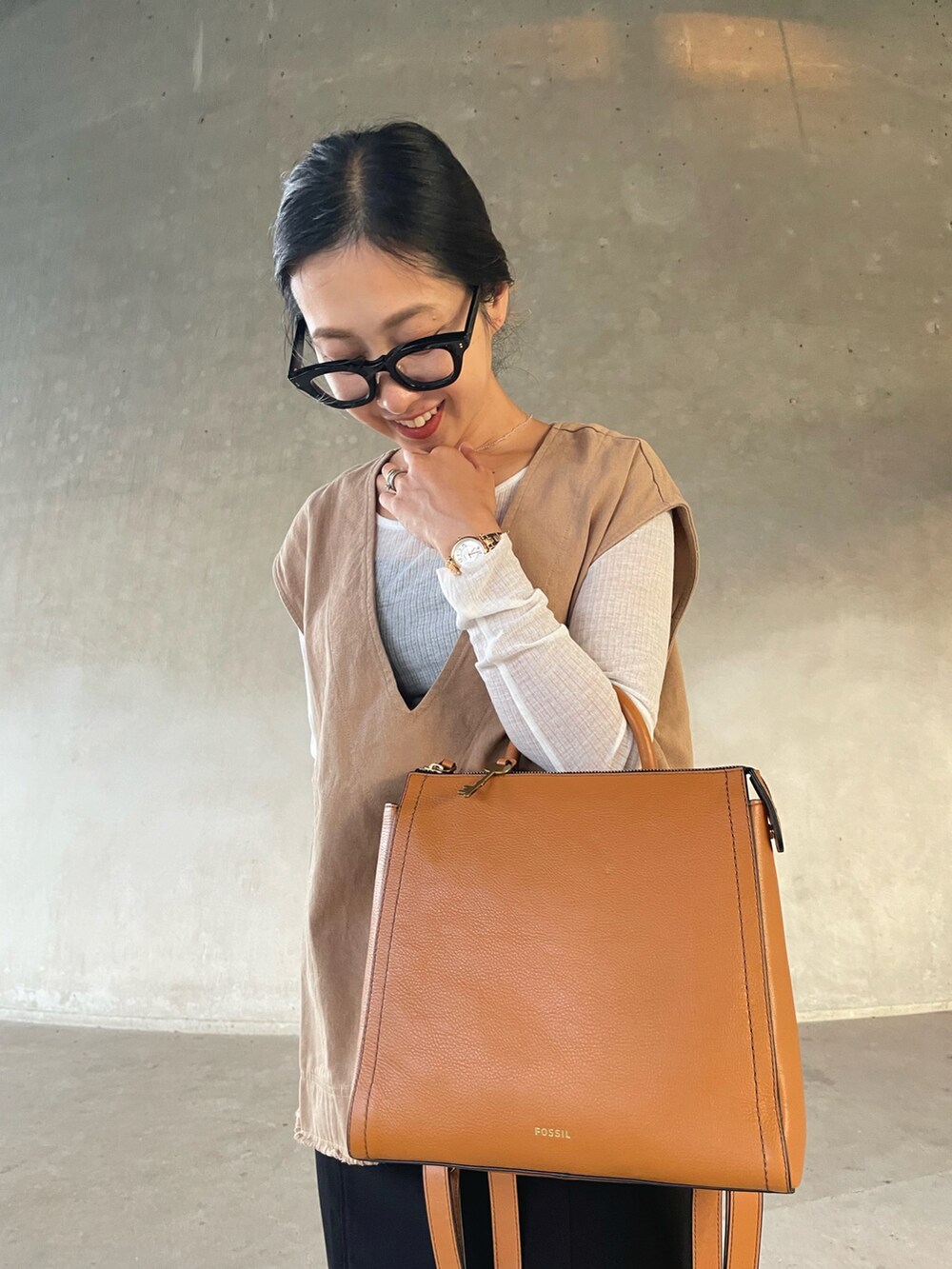 ベージュ系のベスト、ホワイト系のTシャツ/カットソー、イエロー系のバックパック/リュックを着用したレディースの秋コーディネートの3枚目の写真