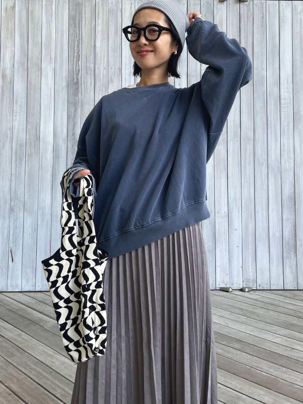 ブルー系のスウェット、グレー系のスカート、ブラック系のトートバッグを着用したレディースの秋コーディネートの5枚目の写真