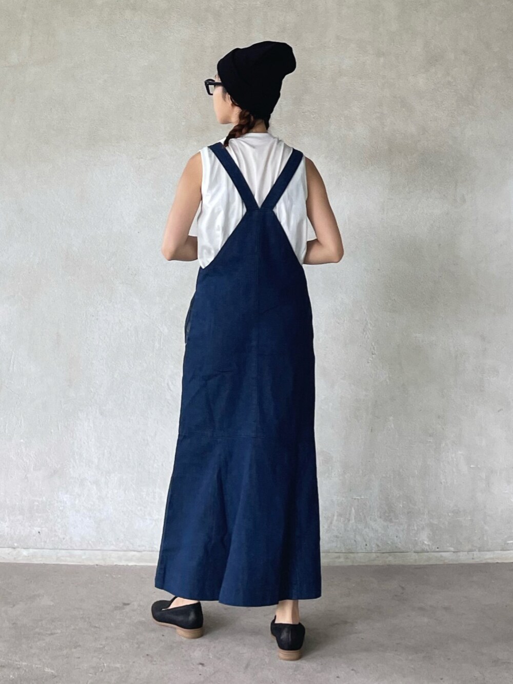 ブルー系のジャンパースカート、ブラック系のトートバッグ、ブラック系のパンプスを着用したレディースの夏コーディネートの3枚目の写真