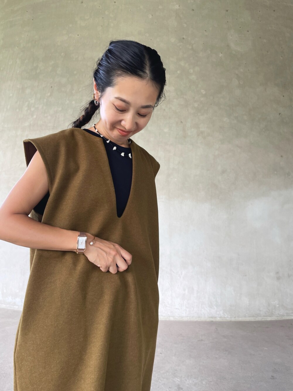 グリーン系のワンピース、ブラック系のモカシン/デッキシューズ、ブルー系のデニムパンツを着用したレディースの秋コーディネートの4枚目の写真