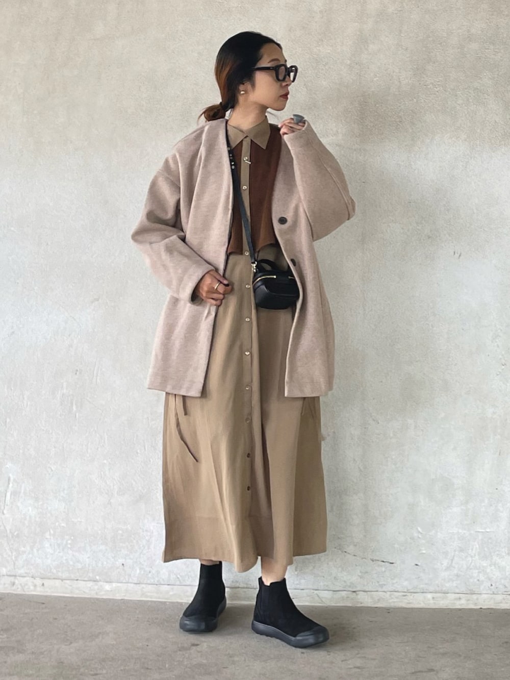 ピンク系のノーカラーコート、ベージュ系のワンピース、ブラック系のブーツを着用したレディースの秋コーディネートの4枚目の写真