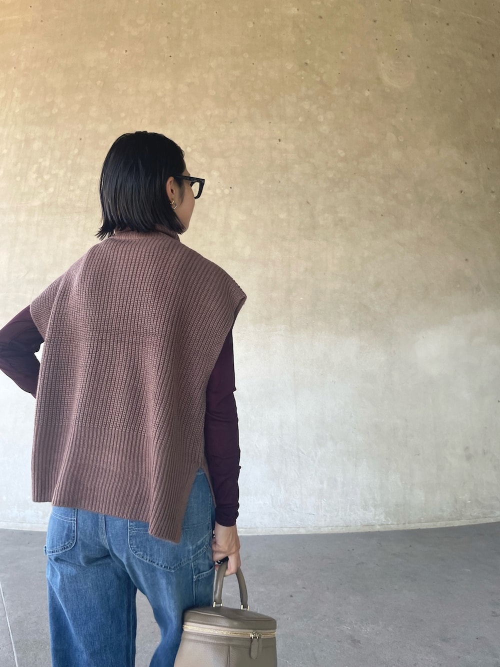 ブラウン系のベスト、ブラウン系のTシャツ/カットソー、ブルー系のデニムパンツを着用したレディースの秋コーディネートの4枚目の写真