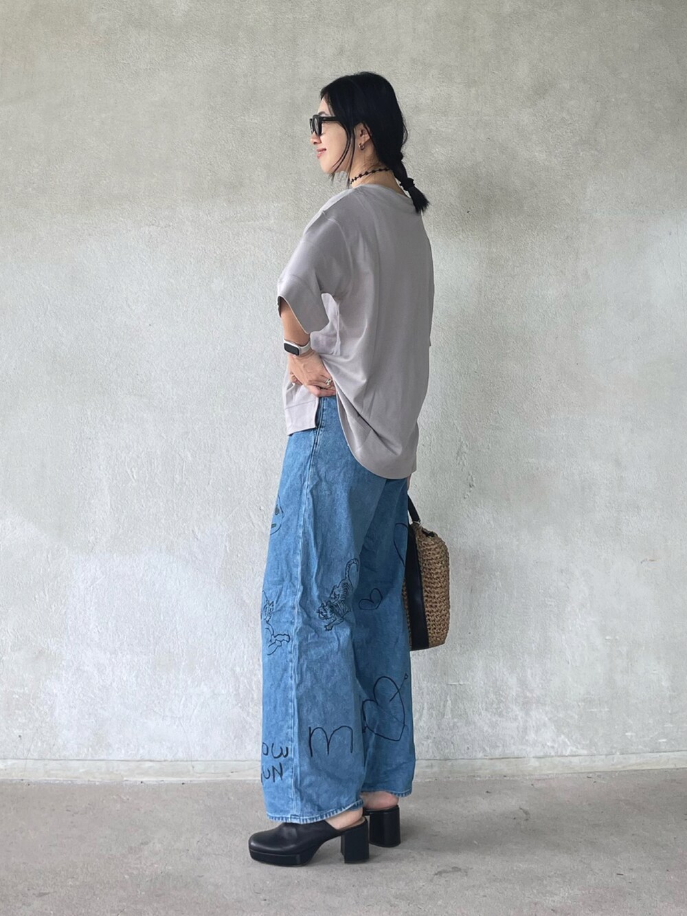 グレー系のTシャツ/カットソー、ブラック系のショルダーバッグ、ブルー系のデニムパンツを着用したレディースの夏コーディネートの2枚目の写真