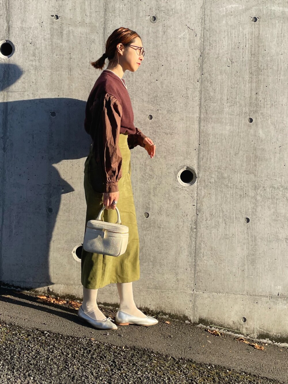 ブラウン系のニット/セーター、グリーン系のスカート、シルバー系のバレエシューズを着用したレディースの冬コーディネートの3枚目の写真