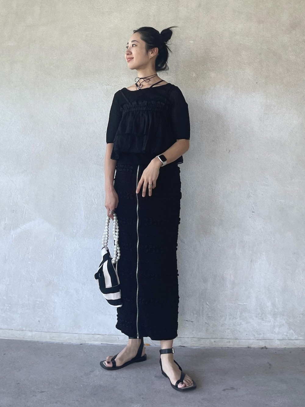 ブラック系のニット/セーター、ブラック系のキャミソール、ブラック系のスカートを着用したレディースの夏コーディネートの4枚目の写真