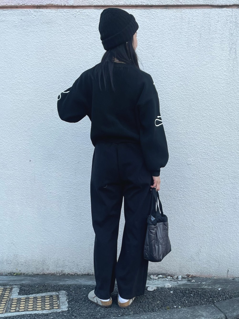 ブラック系のニット/セーター、ブラック系のスウェットパンツ、ベージュ系のサンダルを着用したレディースの冬コーディネートの2枚目の写真