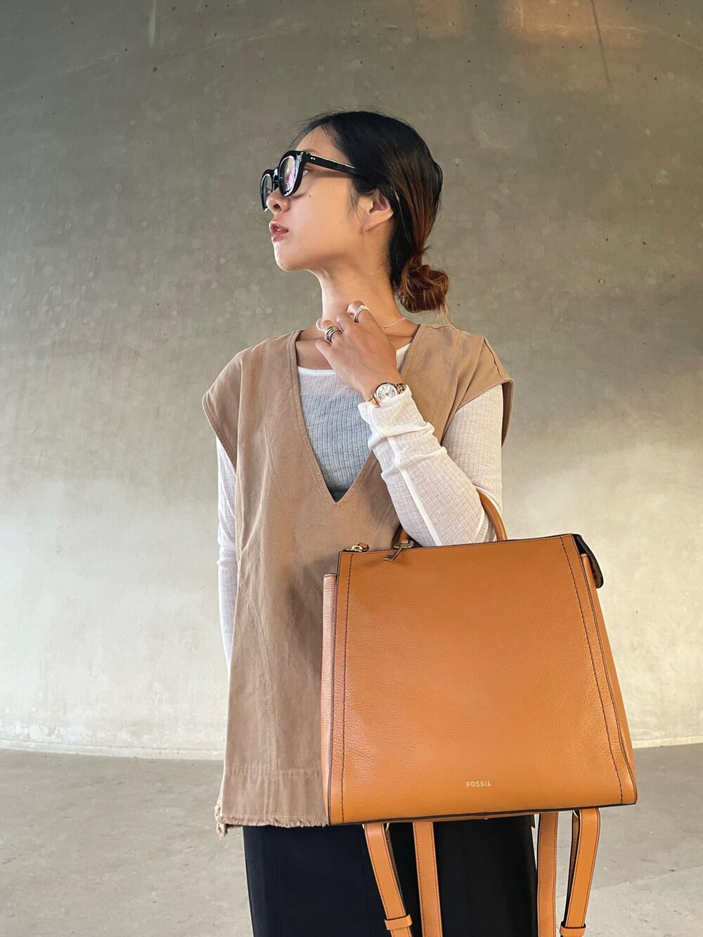 ベージュ系のベスト、ホワイト系のTシャツ/カットソー、イエロー系のバックパック/リュックを着用したレディースの秋コーディネートの4枚目の写真