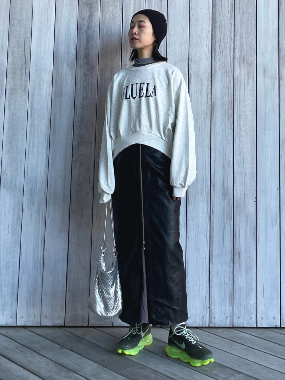 ベージュ系のスウェット、ブラック系のスカート、グリーン系のスニーカーを着用したレディースの冬コーディネートの5枚目の写真