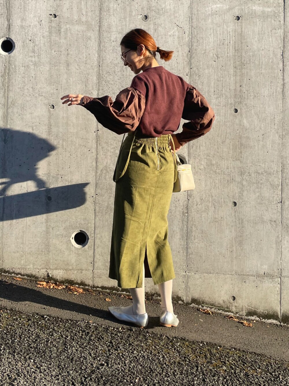 ブラウン系のニット/セーター、グリーン系のスカート、シルバー系のバレエシューズを着用したレディースの冬コーディネートの2枚目の写真