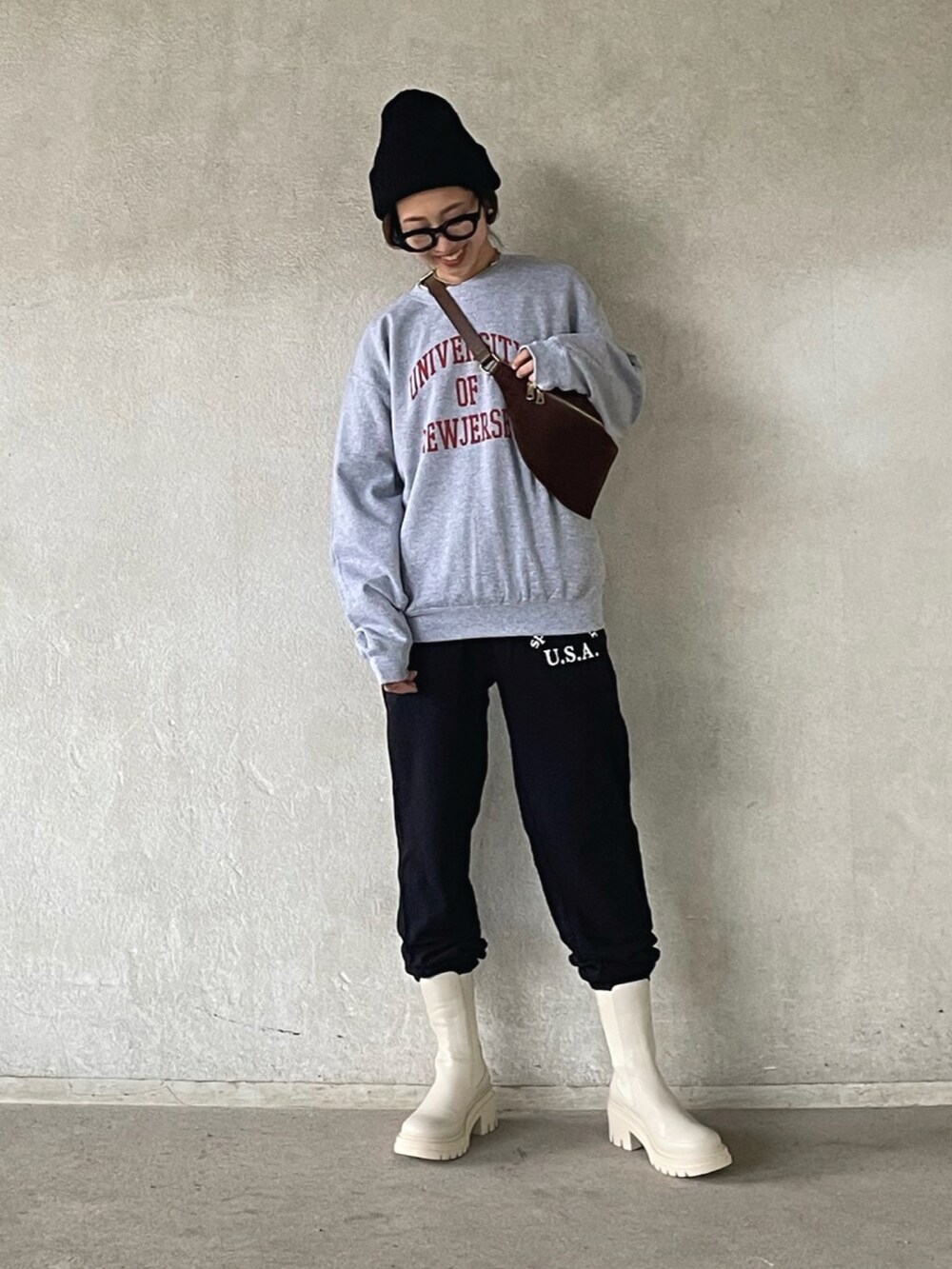 グレー系のスウェット、ブラック系のスウェットパンツ、ベージュ系のブーツを着用したレディースの秋コーディネートの2枚目の写真