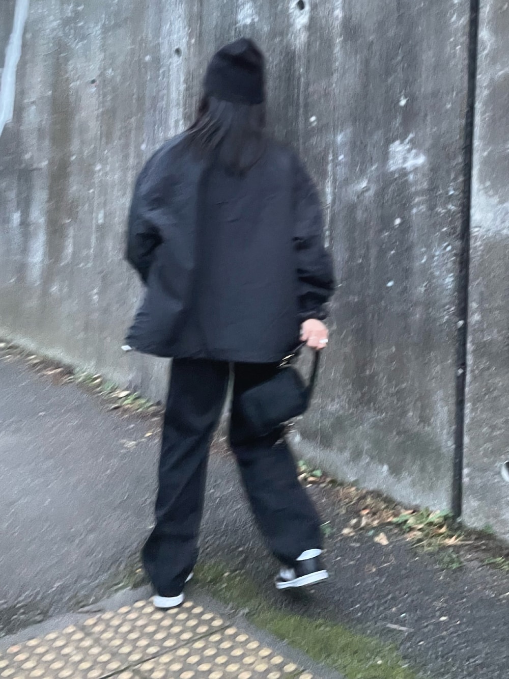 ブラック系のブルゾン、グレー系のTシャツ/カットソー、ブラック系のデニムパンツを着用したレディースの秋コーディネートの2枚目の写真