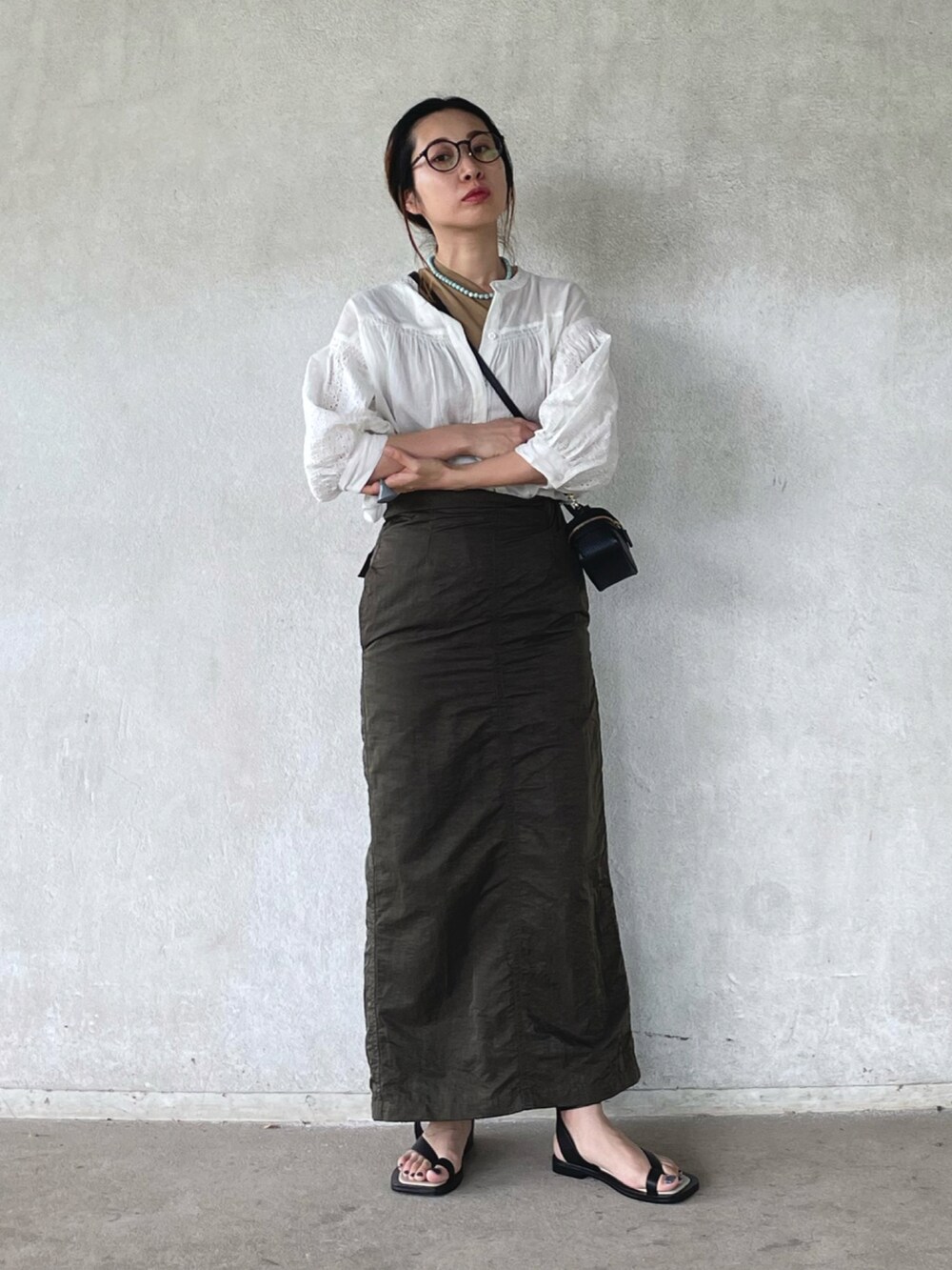 ホワイト系のシャツ/ブラウス、グリーン系のスカート、ブラック系のサンダルを着用したレディースの春コーディネートの5枚目の写真