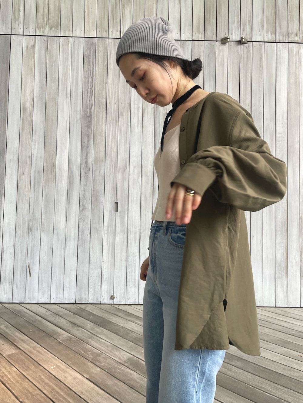 グリーン系のシャツ/ブラウス、ブルー系のデニムパンツ、ブラック系のサンダルを着用したレディースの秋コーディネートの4枚目の写真