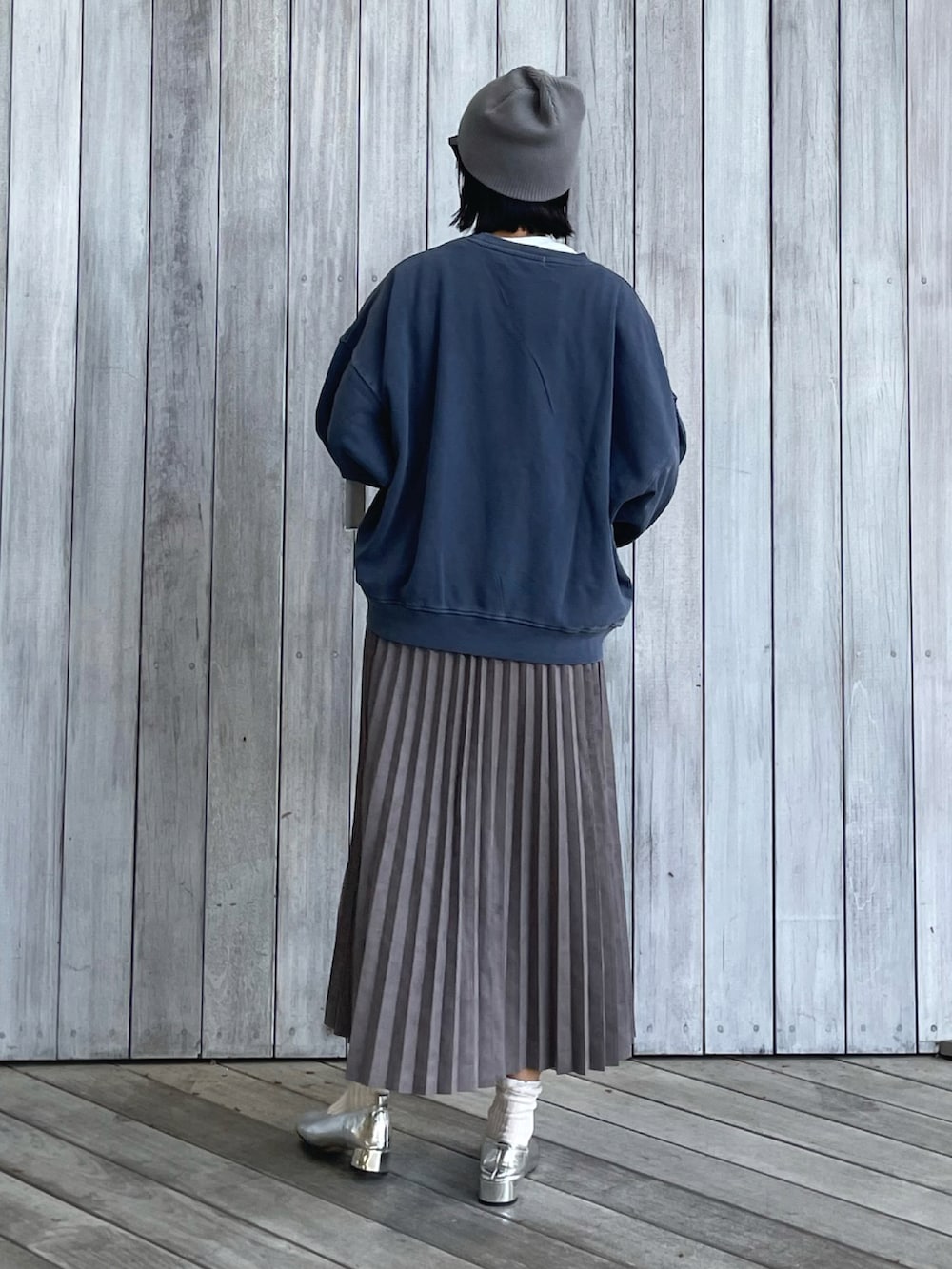 ブルー系のスウェット、グレー系のスカート、ブラック系のトートバッグを着用したレディースの秋コーディネートの4枚目の写真