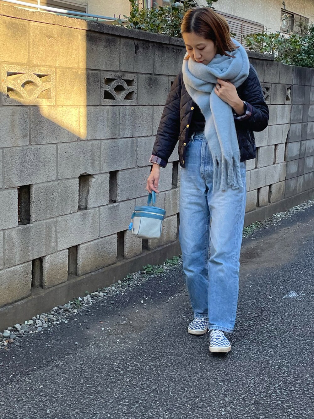 ブルー系のブルゾン、ブルー系のハンドバッグ、ブルー系のスニーカーを着用したレディースの秋コーディネートの2枚目の写真