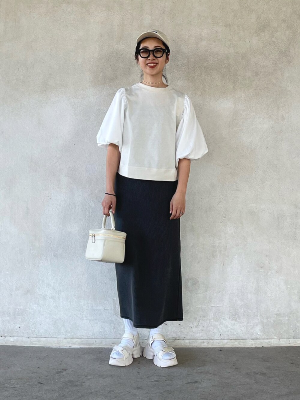 ホワイト系のその他トップス、ブラック系のスカート、ベージュ系のサンダルを着用したレディースの春コーディネートの4枚目の写真