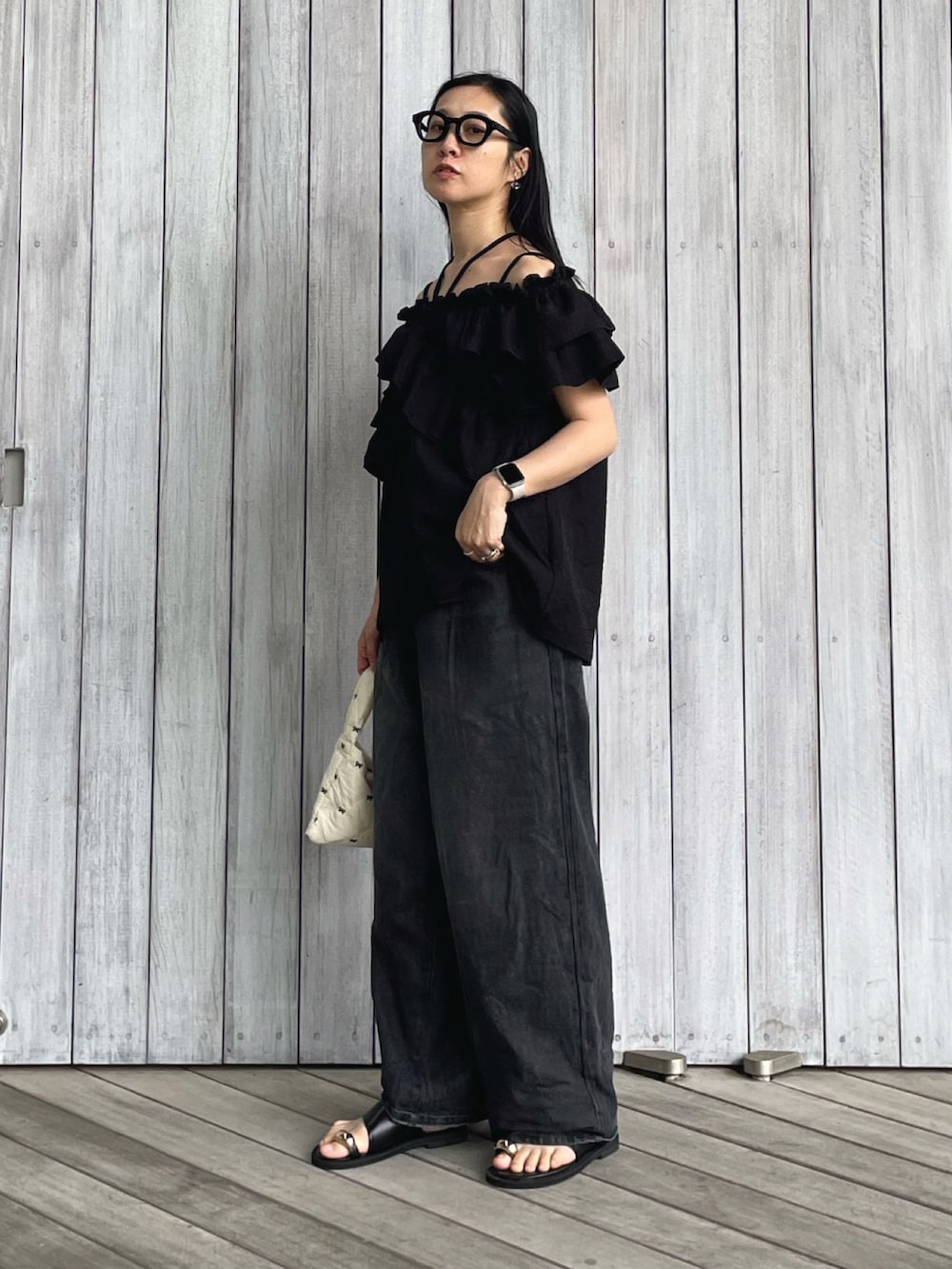 ブラック系のシャツ/ブラウス、ブラック系のデニムパンツ、ブラック系のサンダルを着用したレディースの春コーディネートの2枚目の写真