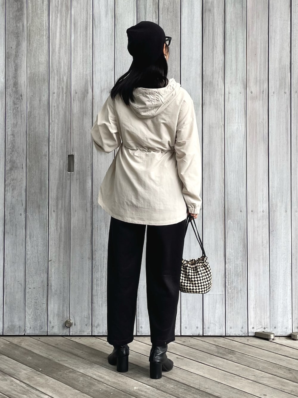 ベージュ系のマウンテンパーカー、ブラック系のスウェットパンツ、ブラック系のショルダーバッグを着用したレディースの秋コーディネートの3枚目の写真