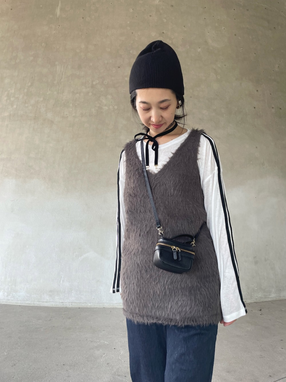 グレー系のベスト、ホワイト系のTシャツ/カットソー、ブルー系のその他パンツを着用したレディースの秋コーディネートの5枚目の写真