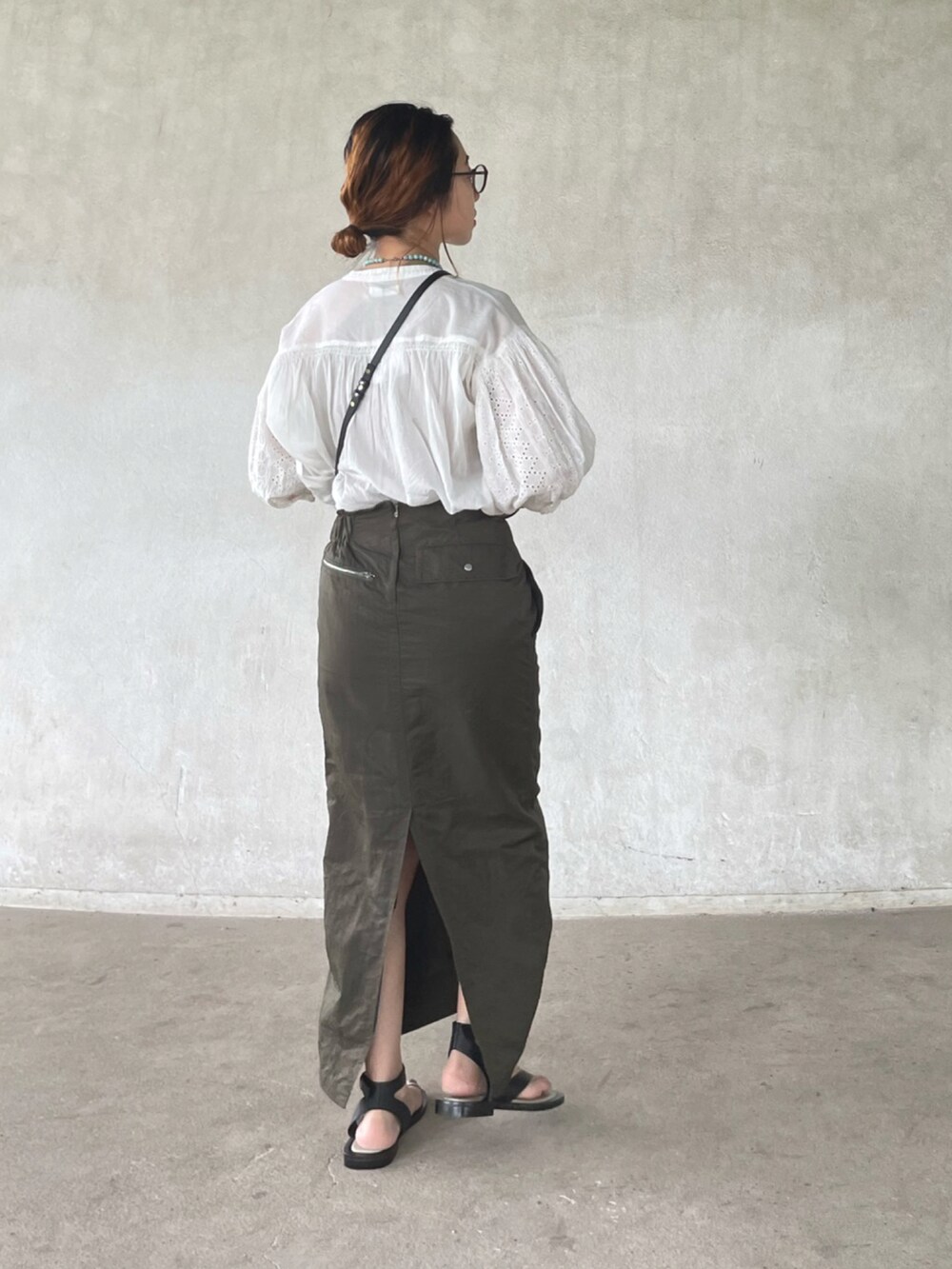 ホワイト系のシャツ/ブラウス、グリーン系のスカート、ブラック系のサンダルを着用したレディースの春コーディネートの3枚目の写真