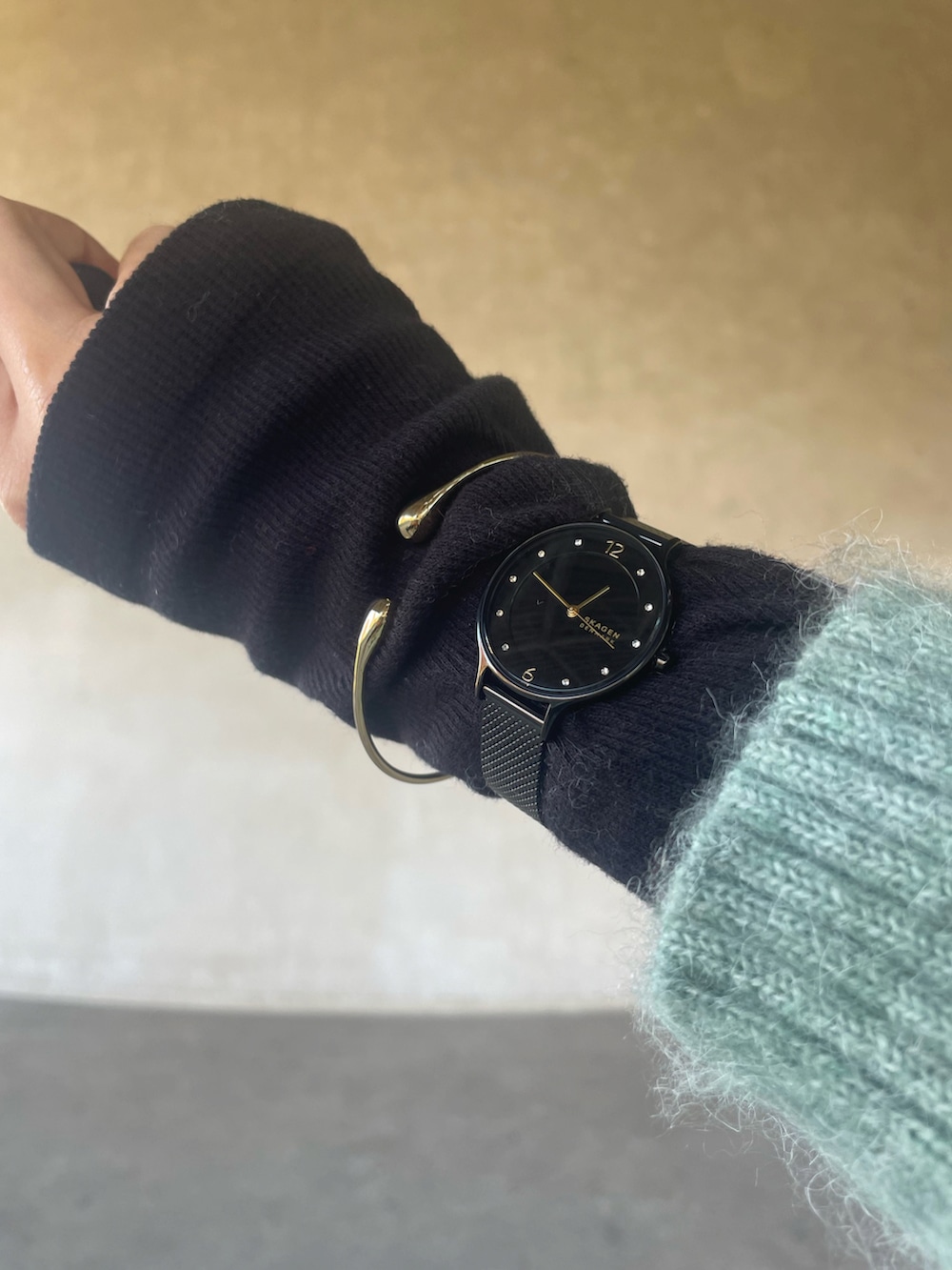 グリーン系のニット/セーター、ホワイト系のスカート、ブラック系のブーツを着用したレディースの冬コーディネートの2枚目の写真