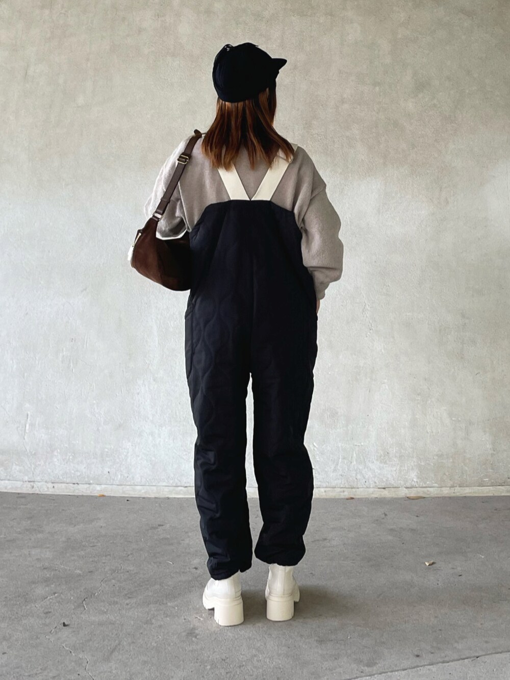 ベージュ系のニット/セーター、ブラック系のサロペット/オーバーオール、ベージュ系のブーツを着用したレディースの秋コーディネートの3枚目の写真