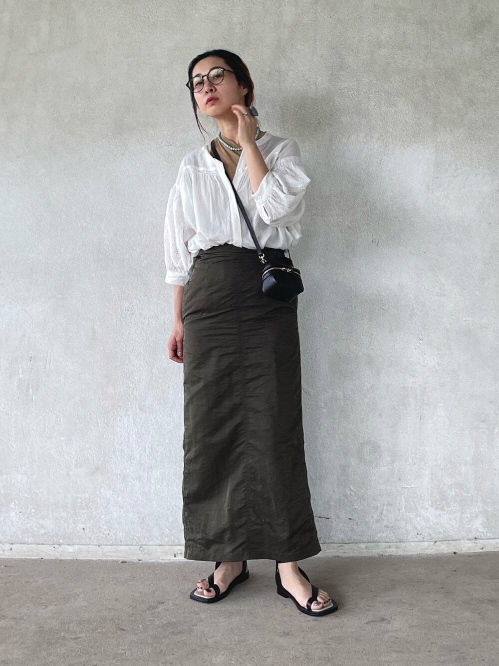 ホワイト系のシャツ/ブラウス、グリーン系のスカート、ブラック系のサンダルを着用したレディースの春コーディネートの2枚目の写真