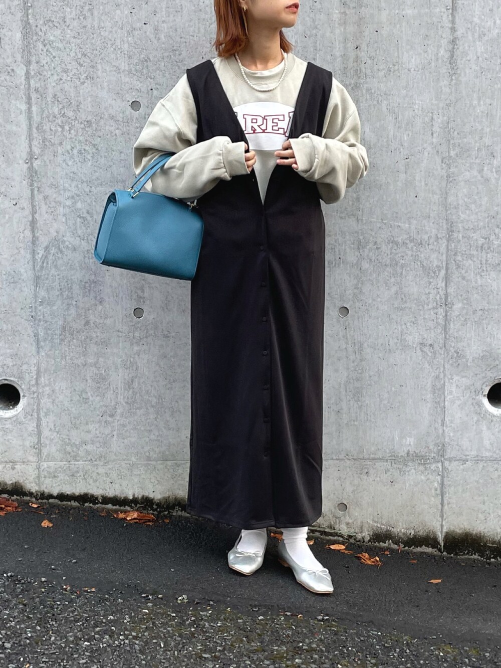 ベージュ系のスウェット、ブラック系のジャンパースカート、シルバー系のバレエシューズを着用したレディースの冬コーディネートの3枚目の写真