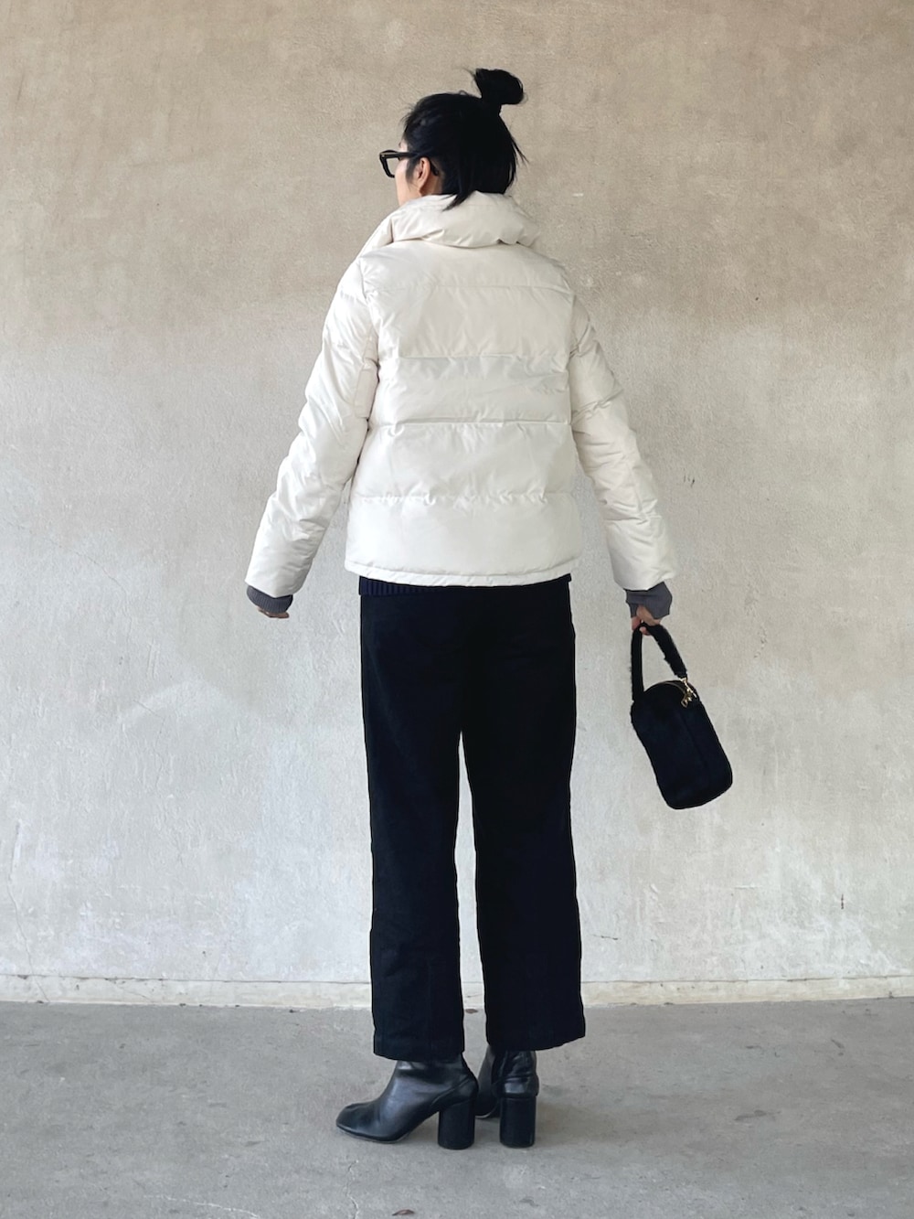ホワイト系のダウンジャケット/コート、ブルー系のベスト、ブラック系のデニムパンツを着用したレディースの冬コーディネートの2枚目の写真