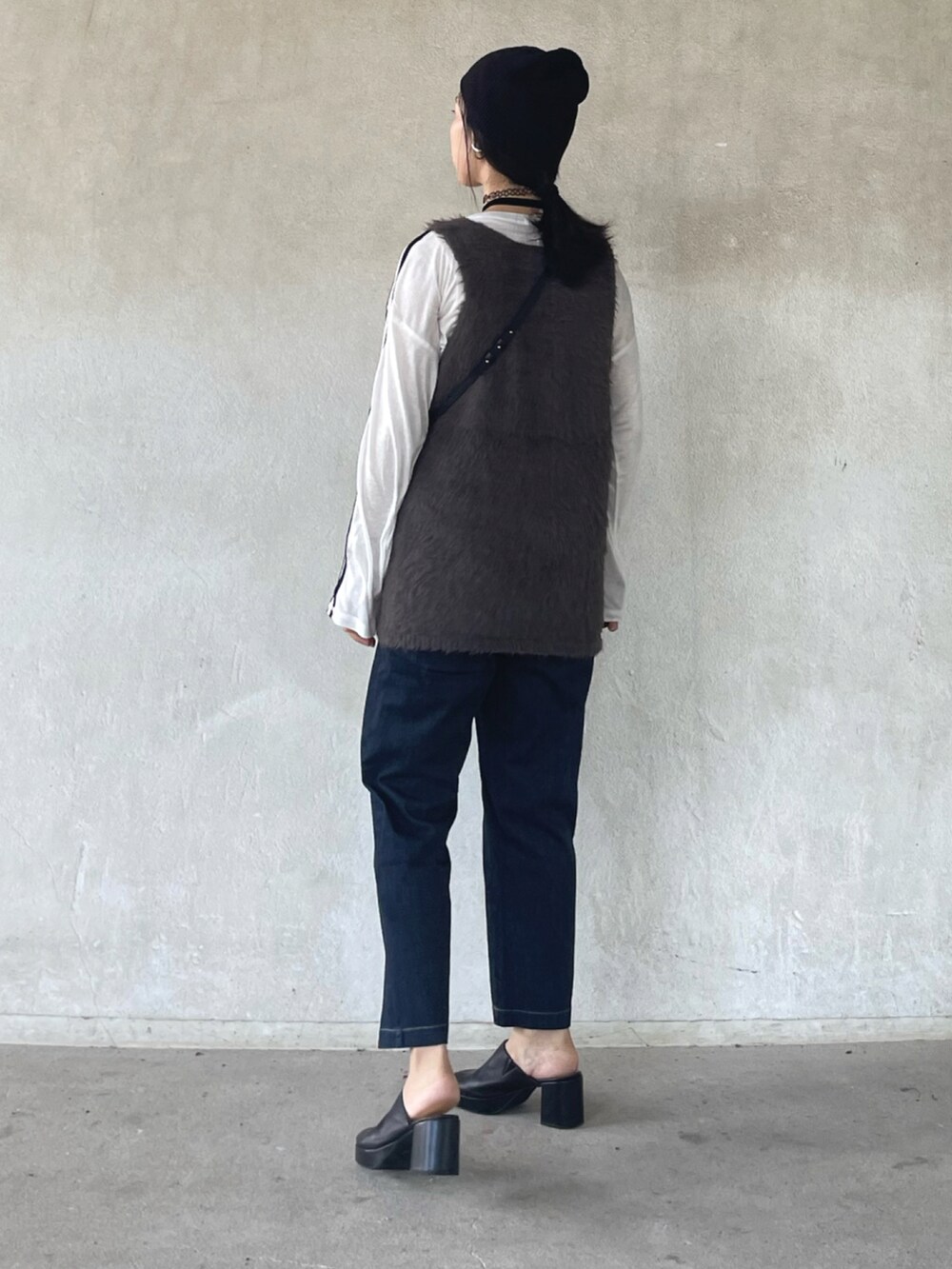 グレー系のベスト、ホワイト系のTシャツ/カットソー、ブルー系のその他パンツを着用したレディースの秋コーディネートの4枚目の写真