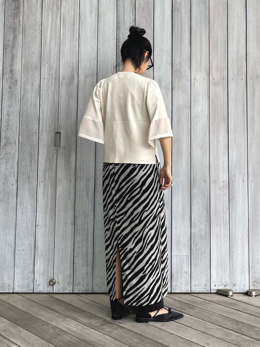 ホワイト系のニット/セーター、ホワイト系のスカート、ブラック系のパンプスを着用したレディースの春コーディネートの5枚目の写真