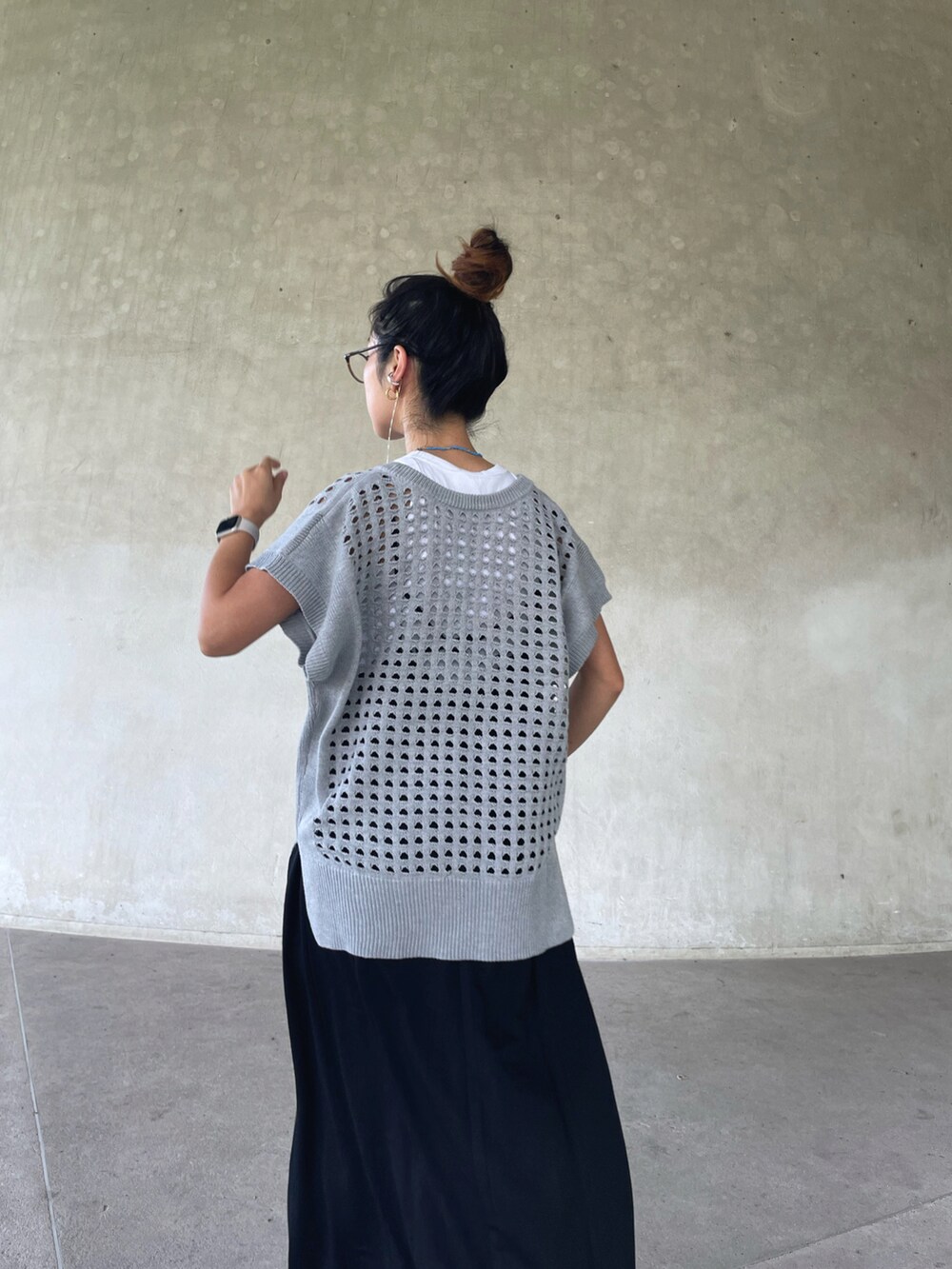 グレー系のベスト、ブラック系のワンピース、ブラック系のサンダルを着用したレディースの夏コーディネートの2枚目の写真