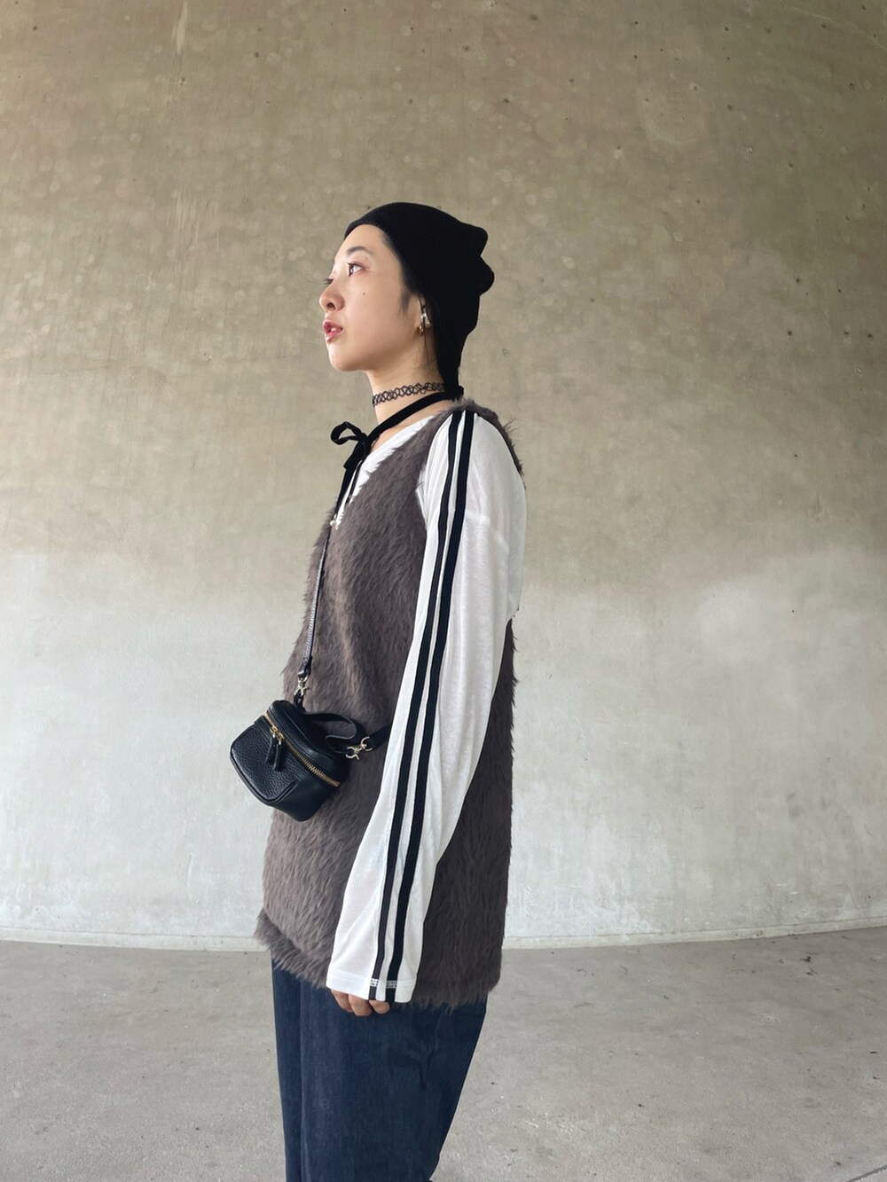 グレー系のベスト、ホワイト系のTシャツ/カットソー、ブルー系のその他パンツを着用したレディースの秋コーディネートの3枚目の写真