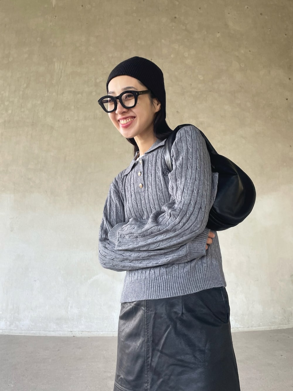 グレー系のニット/セーター、ブラック系のスカート、ホワイト系のスニーカーを着用したレディースの秋コーディネートの5枚目の写真