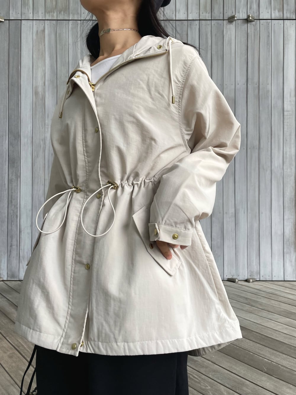 ベージュ系のマウンテンパーカー、ブラック系のスウェットパンツ、ブラック系のショルダーバッグを着用したレディースの秋コーディネートの2枚目の写真