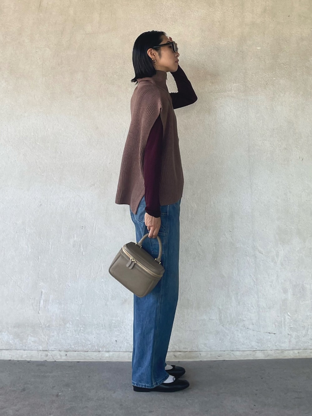 ブラウン系のベスト、ブラウン系のTシャツ/カットソー、ブルー系のデニムパンツを着用したレディースの秋コーディネートの3枚目の写真