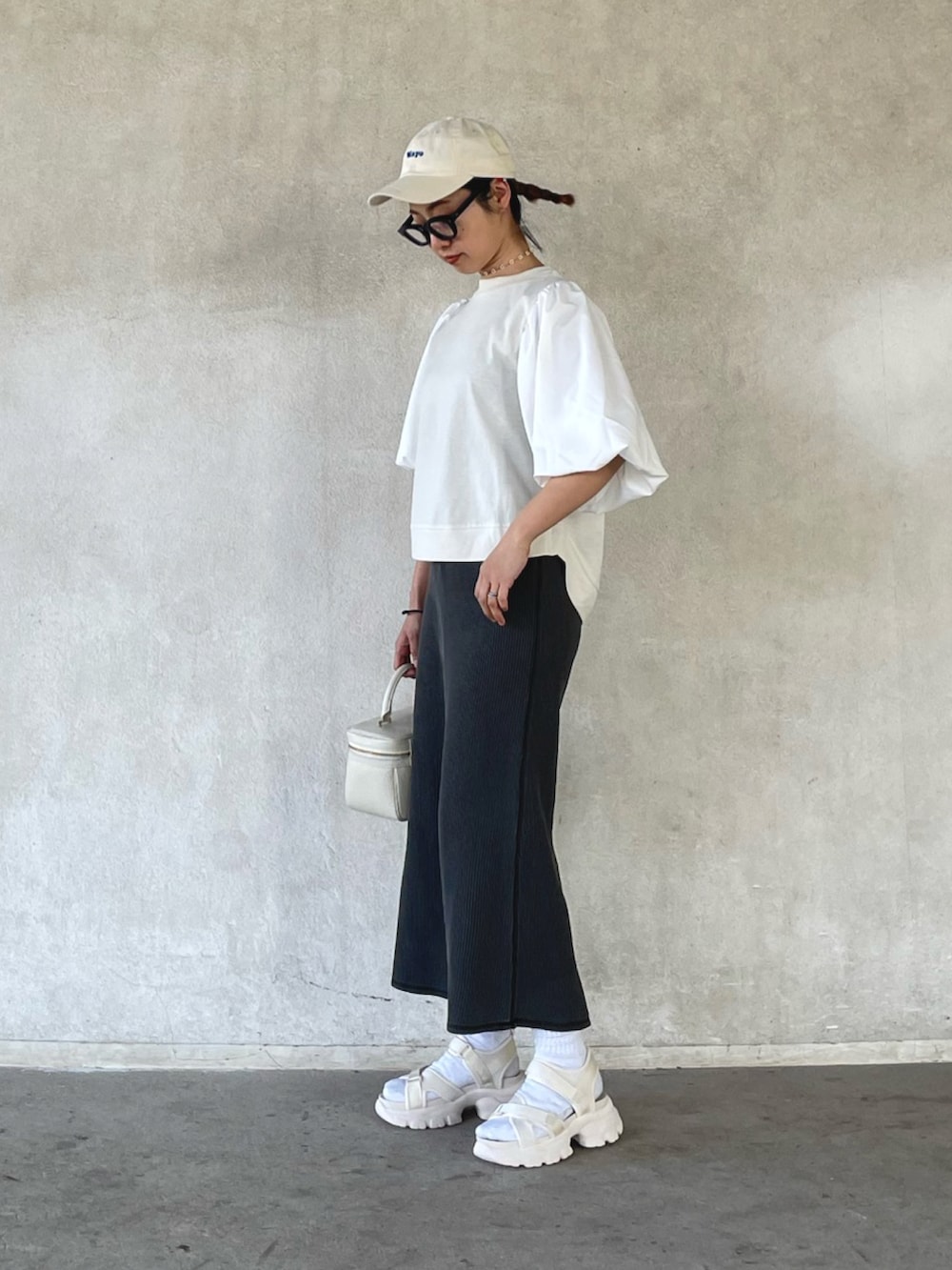 ホワイト系のその他トップス、ブラック系のスカート、ベージュ系のサンダルを着用したレディースの春コーディネートの3枚目の写真