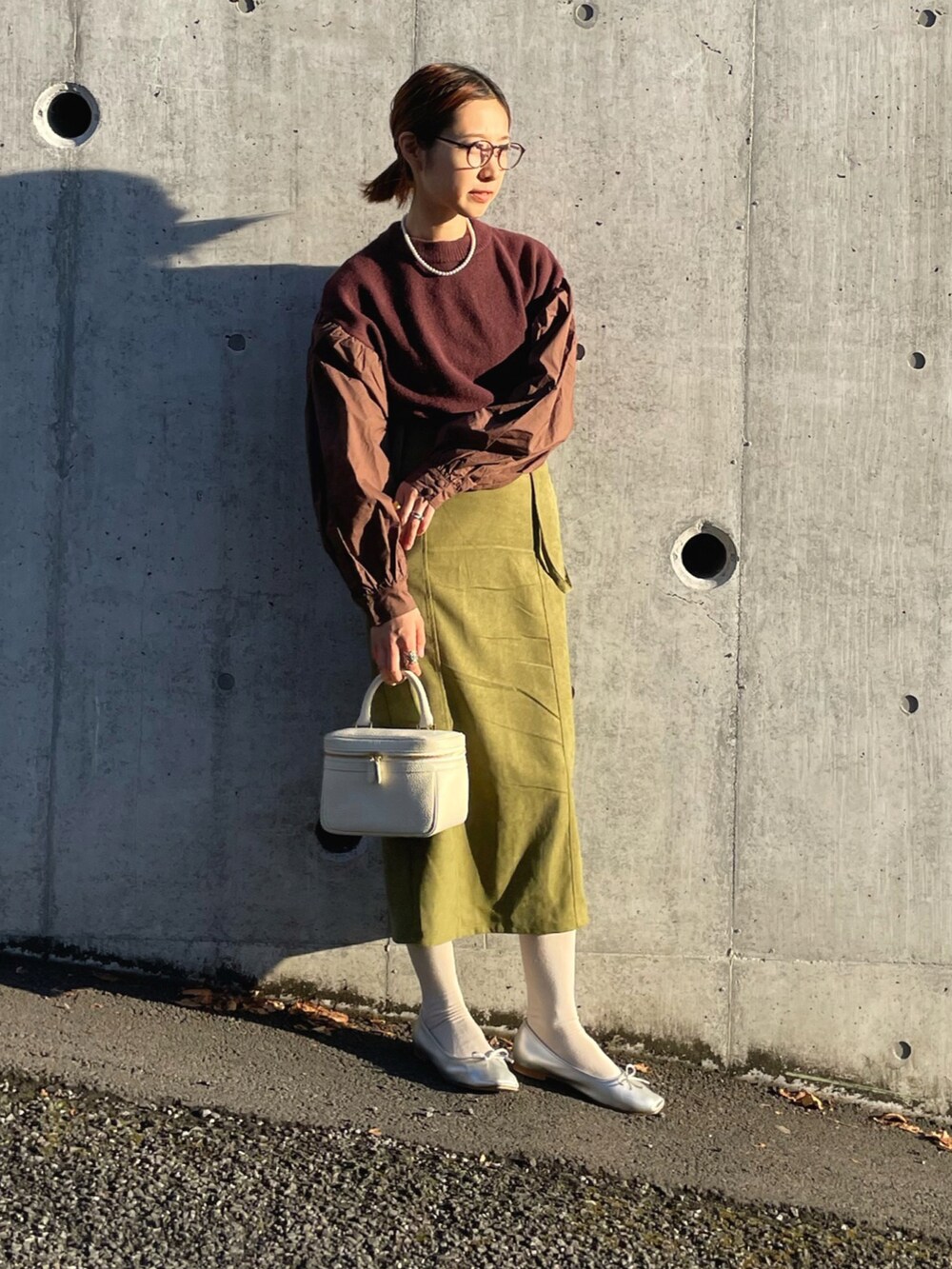 ブラウン系のニット/セーター、グリーン系のスカート、シルバー系のバレエシューズを着用したレディースの冬コーディネートの5枚目の写真