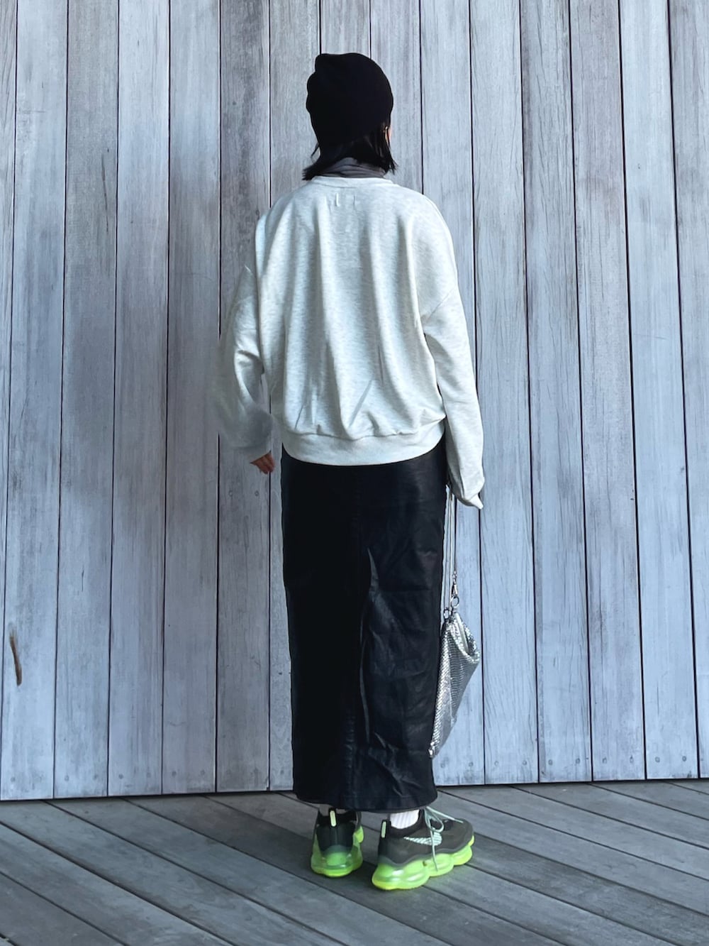 ベージュ系のスウェット、ブラック系のスカート、グリーン系のスニーカーを着用したレディースの冬コーディネートの3枚目の写真