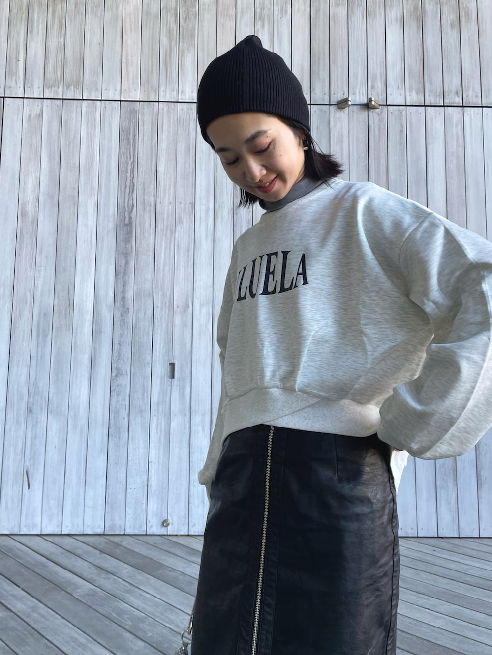 ベージュ系のスウェット、ブラック系のスカート、グリーン系のスニーカーを着用したレディースの冬コーディネートの2枚目の写真