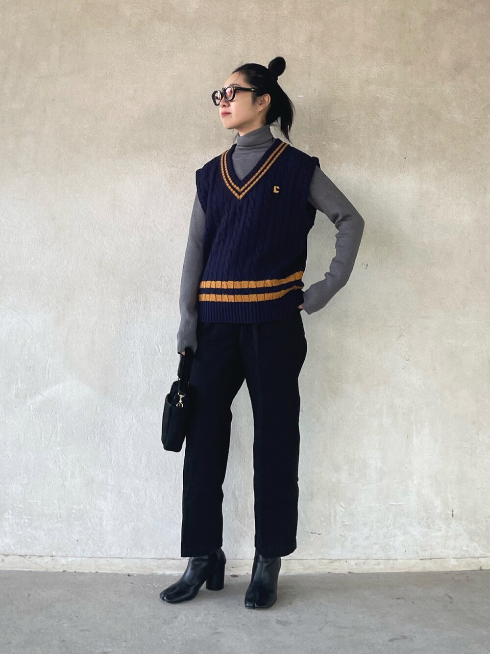 ホワイト系のダウンジャケット/コート、ブルー系のベスト、ブラック系のデニムパンツを着用したレディースの冬コーディネートの5枚目の写真