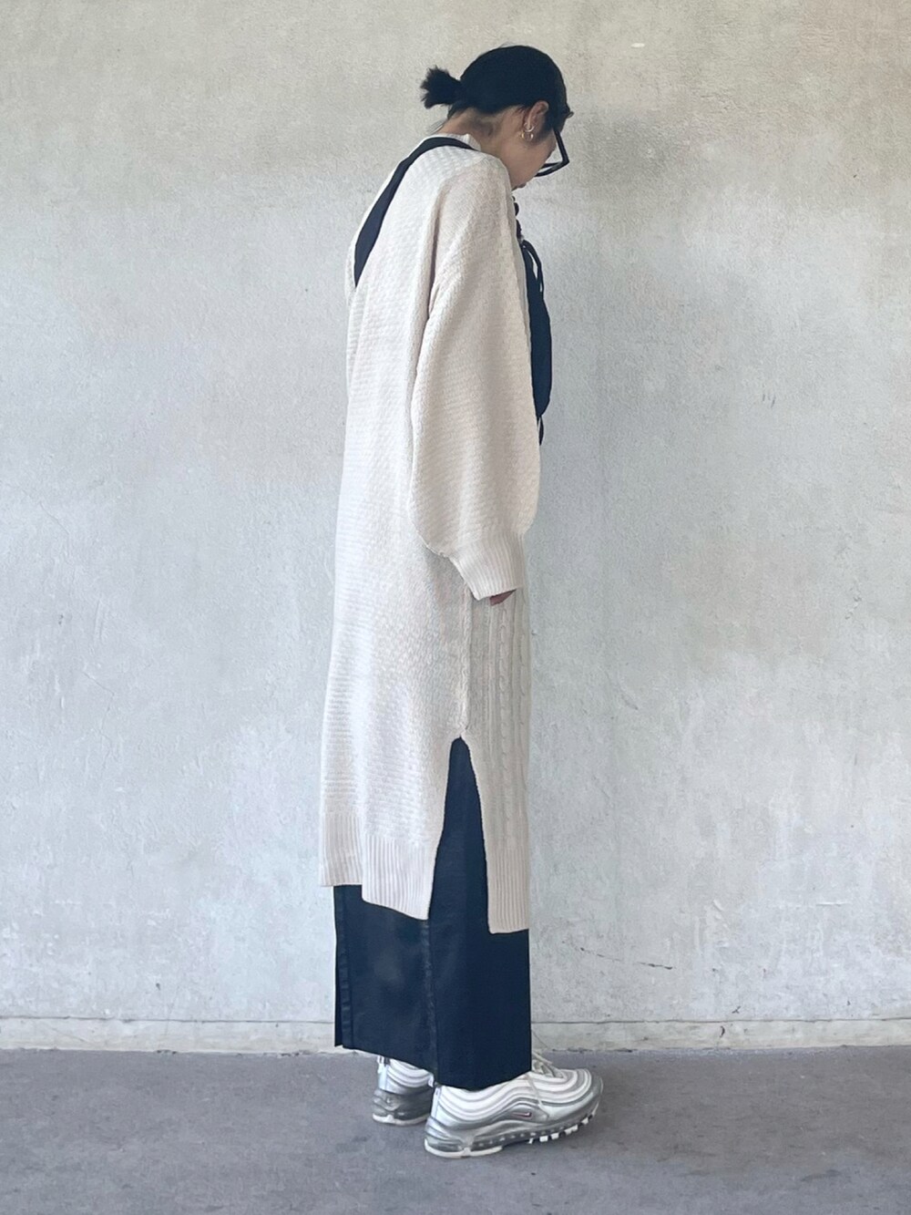 ホワイト系のワンピース、ブラック系のスカート、ブラック系のショルダーバッグを着用したレディースの秋コーディネートの4枚目の写真