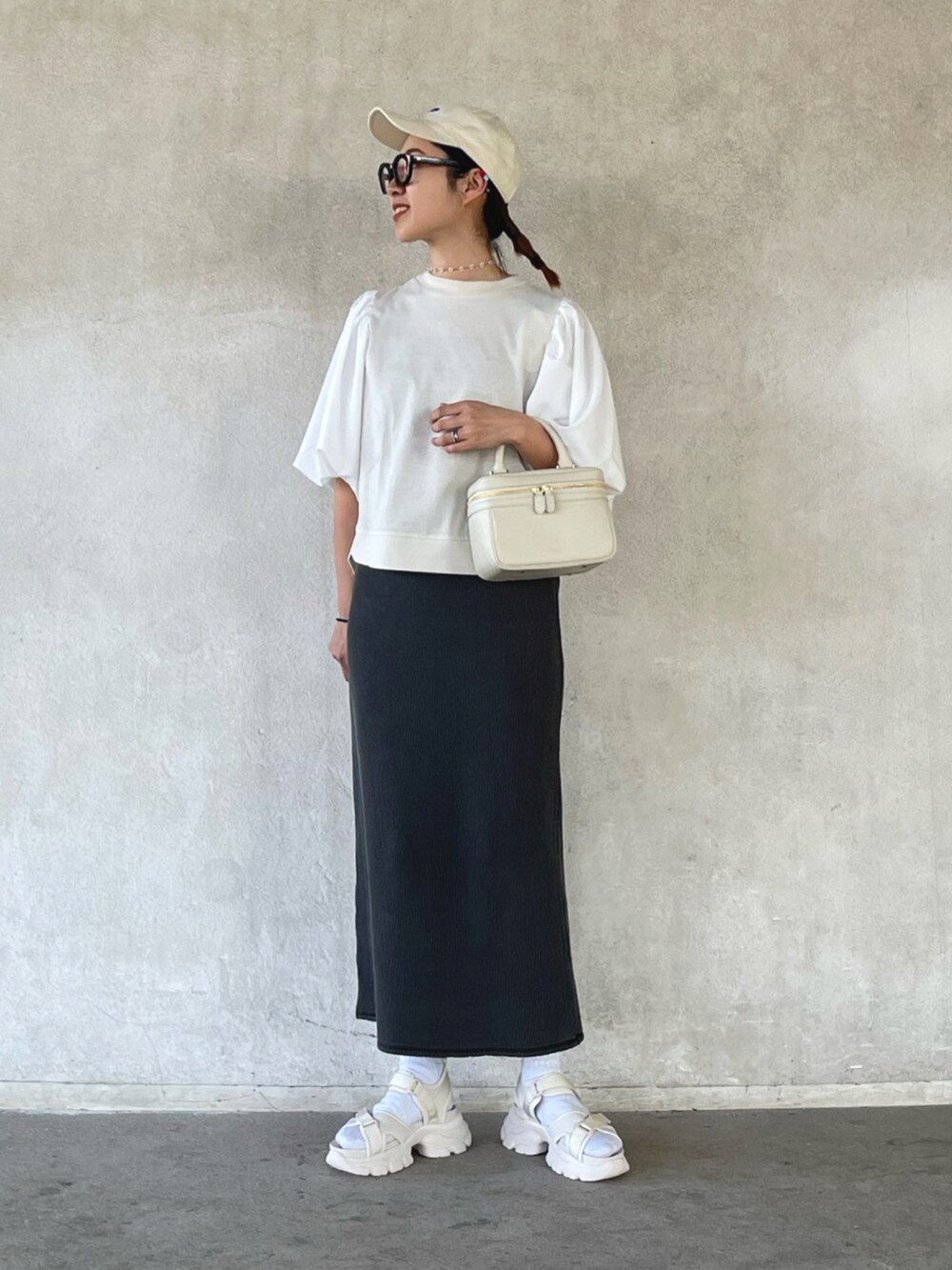 ホワイト系のその他トップス、ブラック系のスカート、ベージュ系のサンダルを着用したレディースの春コーディネートの2枚目の写真