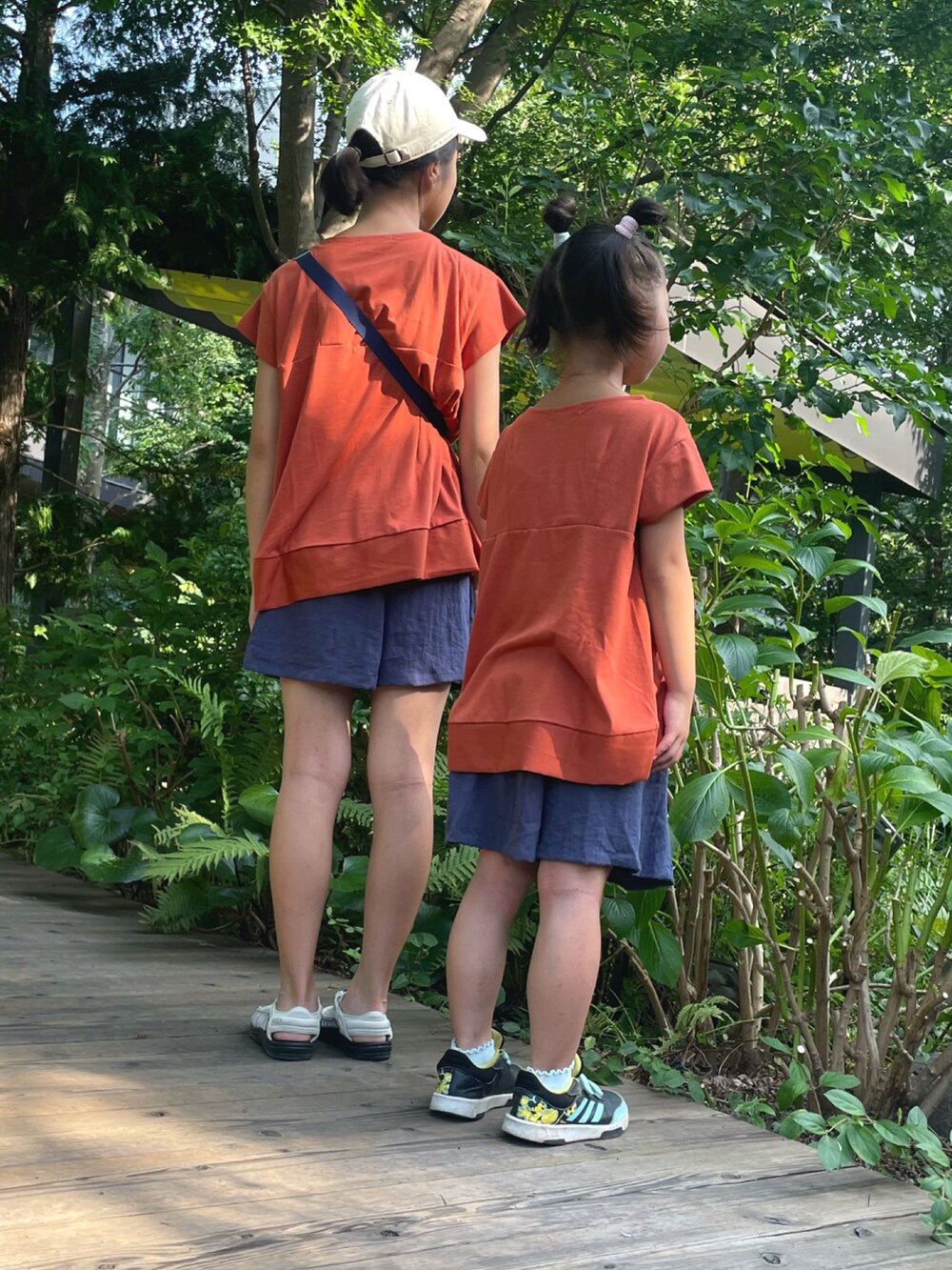 オレンジ系のTシャツ/カットソー、オレンジ系のTシャツ/カットソー、ブルー系のスカートを着用したレディースの夏コーディネートの3枚目の写真