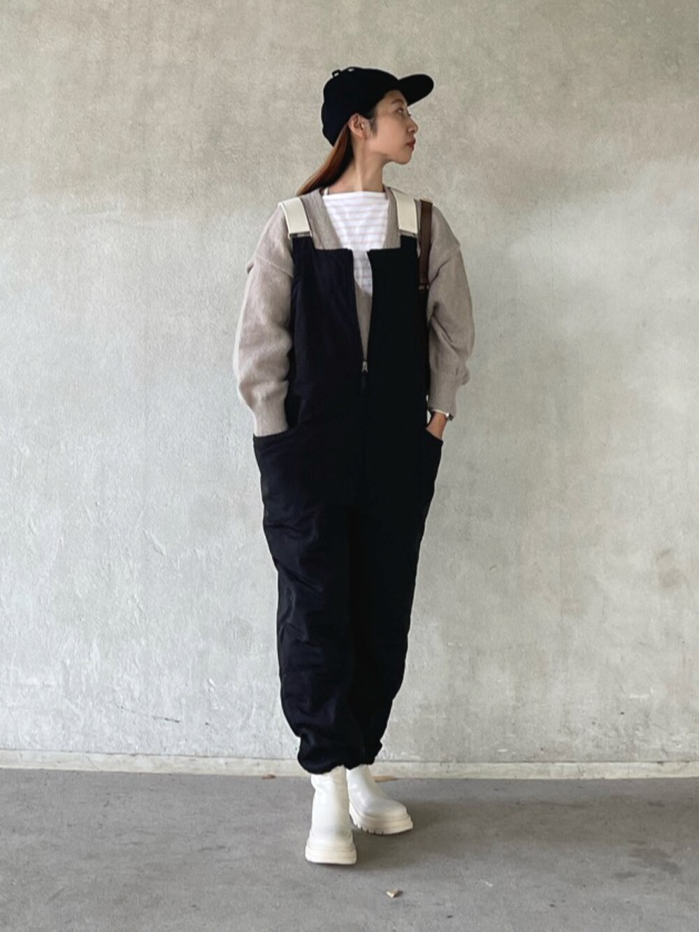 ベージュ系のニット/セーター、ブラック系のサロペット/オーバーオール、ベージュ系のブーツを着用したレディースの秋コーディネートの2枚目の写真