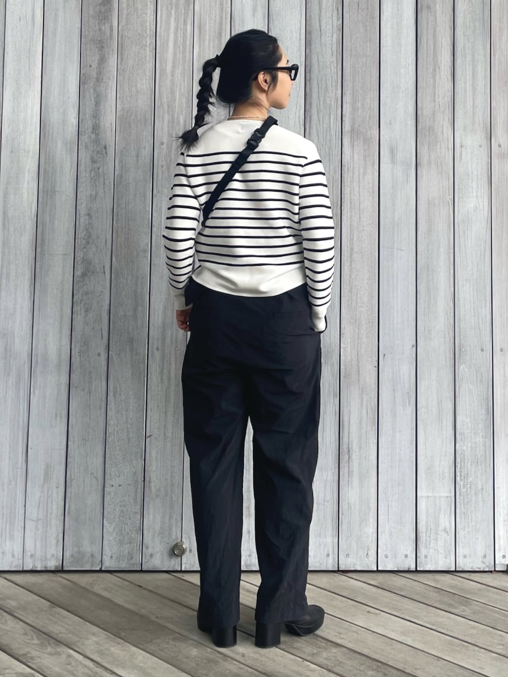 ホワイト系のニット/セーター、ブラック系のつなぎ/オールインワン、ブラック系のサンダルを着用したレディースの春コーディネートの3枚目の写真