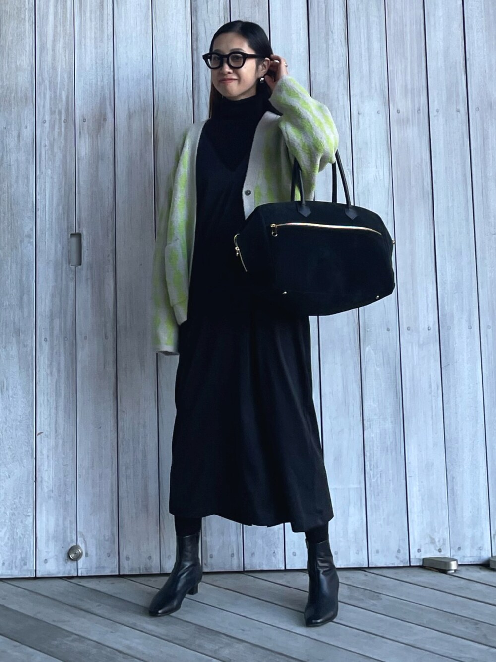 グリーン系のカーディガン/ボレロ、ブラック系のブーツ、ブラック系のサロペット/オーバーオールを着用したレディースの秋コーディネートの3枚目の写真