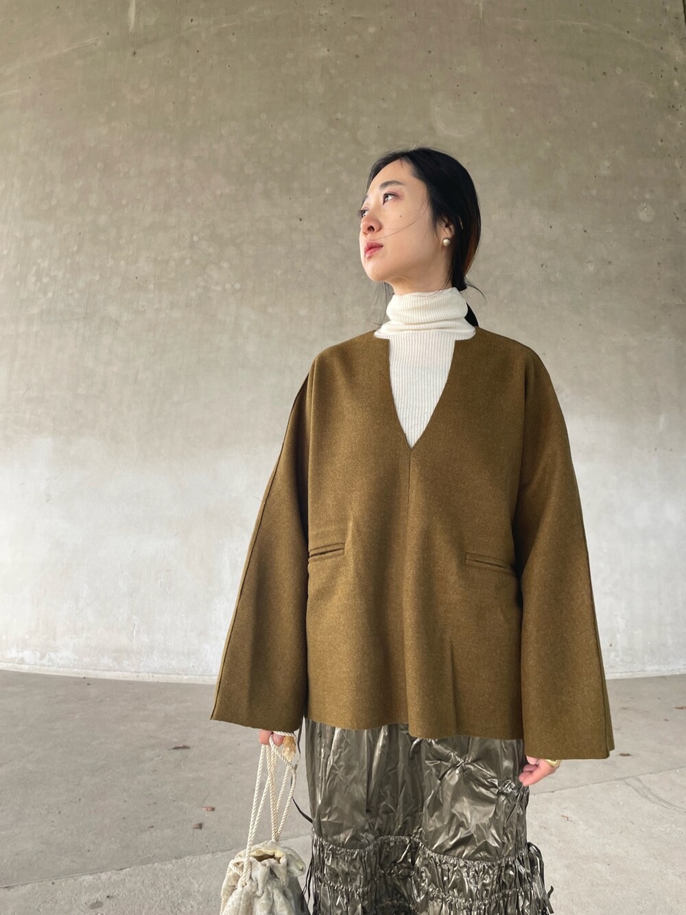 グリーン系のTシャツ/カットソー、シルバー系のスカートを着用したレディースの冬コーディネートの3枚目の写真