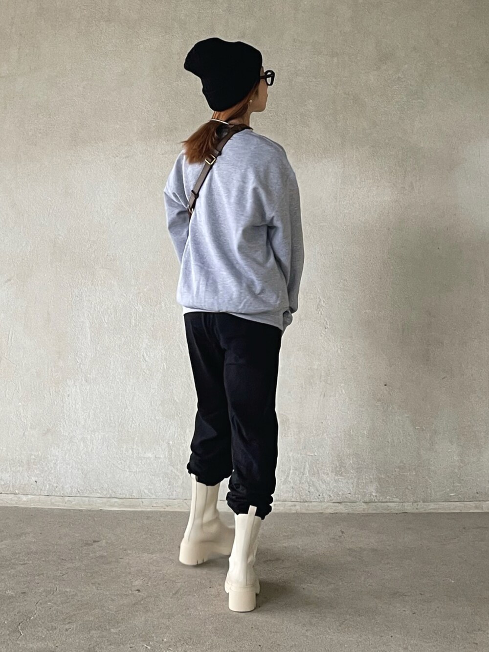 グレー系のスウェット、ブラック系のスウェットパンツ、ベージュ系のブーツを着用したレディースの秋コーディネートの3枚目の写真